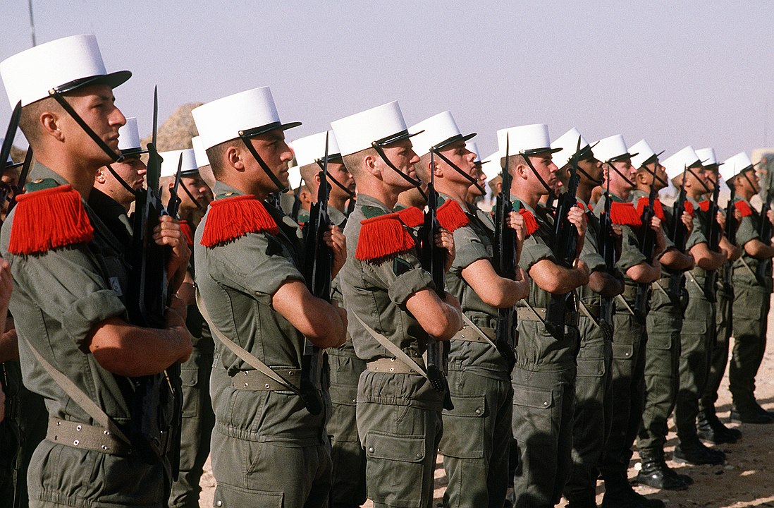 Kompania honorowa żołnierzy 6. Batalionu Francuskiej Legii Cudzoziemskiej oczekująca na przybycie generała Khalida Bin Sultana Bin Abdula Aziza(ang.) dowódcy sił zbrojnych Arabii Saudyjskiej podczas operacji wojskowej Pustynna Burza 14 maja 1992, fot. wikimedia (domena publiczna)