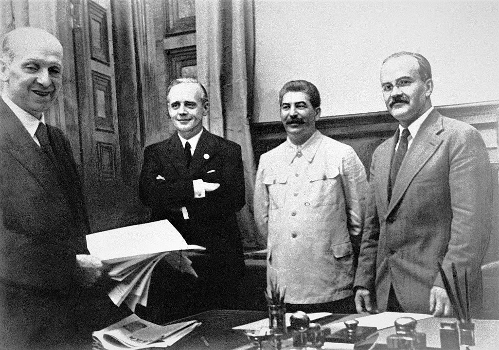 23 sierpnia 1939 roku w Moskwie. Od lewej stoją: szef działu prawnego niemieckiego MSZ Friedrich Gauss, niemiecki minister spraw zagranicznych Joachim von Ribbentrop, Józef Stalin oraz minister spraw zagranicznych ZSRR Wiaczesław Mołotow, wikimedia (domena publiczna)